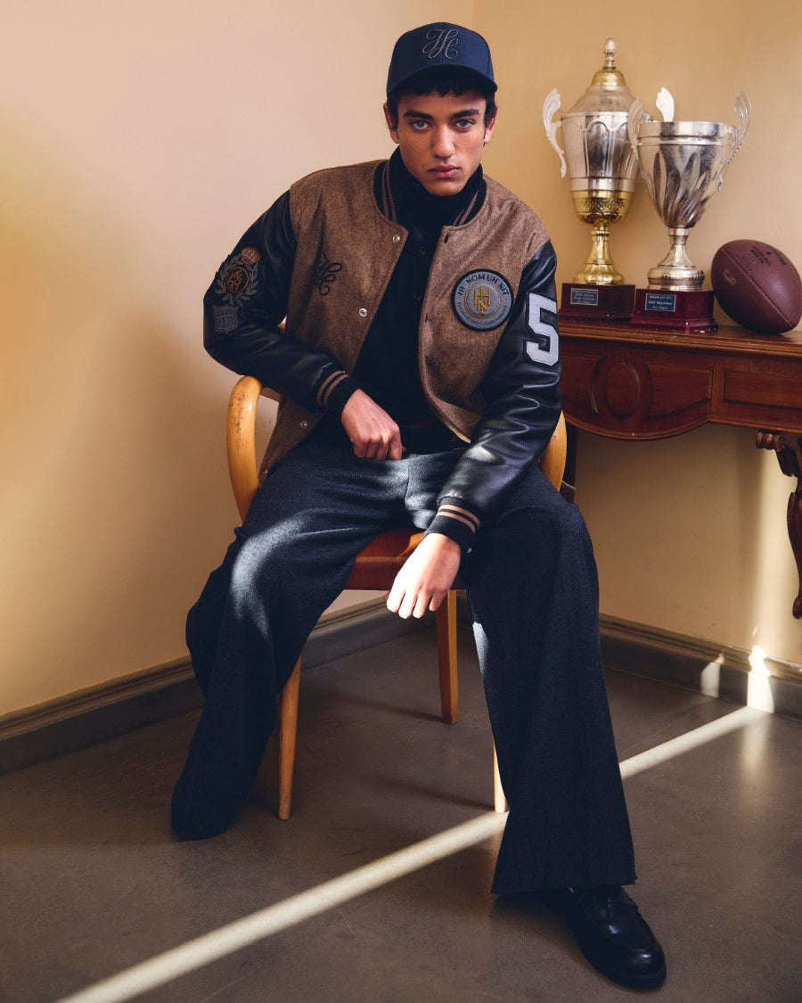 IH NOM UH NIT Fall/Winter 2026 look with Patch Varsity Jacket, Monogram Embroidered Cap and wide-leg flannel pants