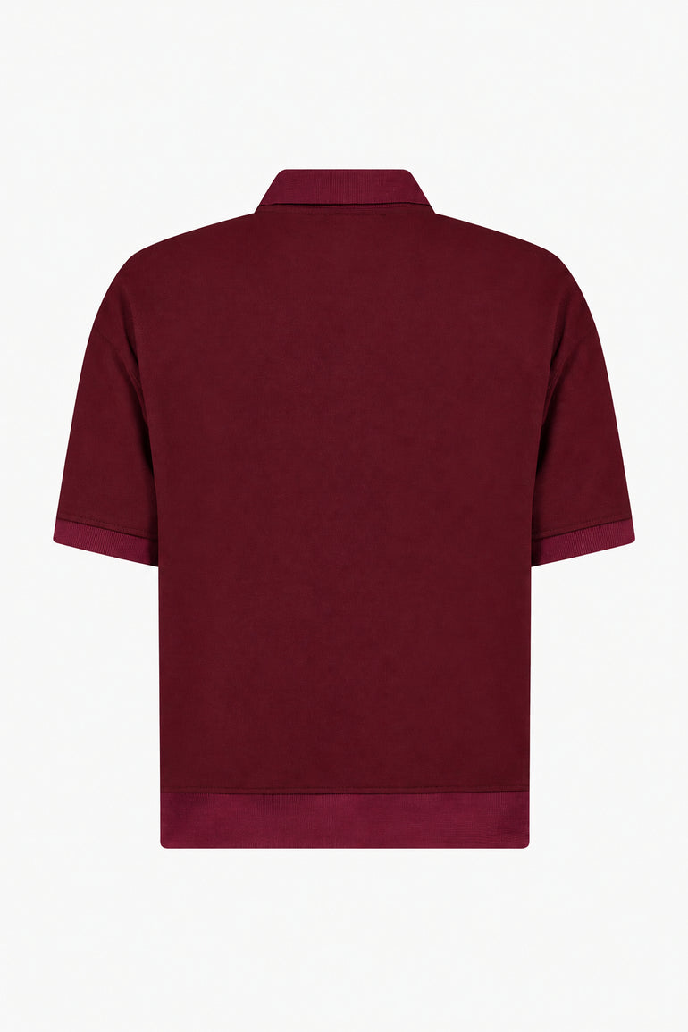 IH NOM UH NIT FW26 burgundy short-sleeve polo shirt with plain back and ribbed hem, back view.